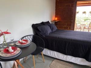 a bedroom with a bed and a table with two plates of food at Chalé Makar - Hidromassagem aquecida e vista para as montanhas in Serra do Cipo