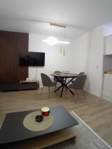a living room with a table and chairs and a tv at Stan na dan Bor in Bor