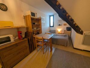 a room with a bed and a table with a desk at Studio pied des pistes in Réallon