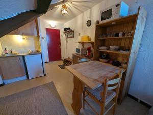 a kitchen with a wooden table and a kitchen with a microwave at Studio pied des pistes in Réallon
