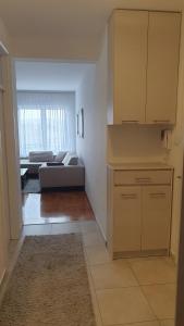 a room with a kitchen and a living room with a couch at Apartman 44, sa garažom, Mejdan Banja Luka in Banja Luka