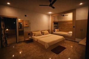 a large bedroom with a bed and a mirror at The Wilds Villa Gir Jungle Stay with Swimming Pool in Sasan Gir