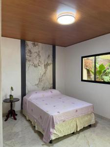 a bedroom with a bed and a table in it at Hostal Casa Hope in Rivas