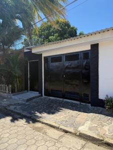 a garage with black doors on a house at Hostal Casa Hope in Rivas