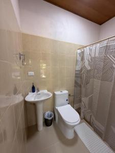 a bathroom with a toilet and a sink and a shower at Hostal Casa Hope in Rivas