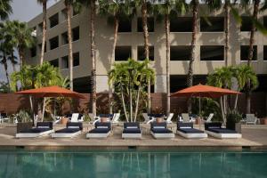 a group of lounge chairs and umbrellas next to a pool at Epicurean Hotel, Autograph Collection in Tampa