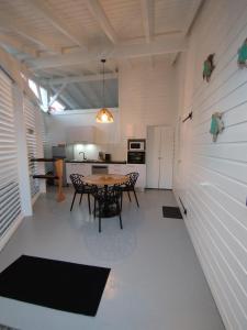a kitchen and dining room with a table and chairs at Logement chic au style tropical contemporain in Îlet à Christophe
