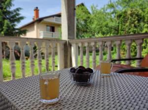 a table with a bowl of fruit and two glasses of juice at Pandora Apartments Sarajevo in Sarajevo