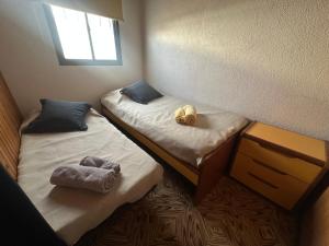 two twin beds in a room with towels on them at La casa de Chola in Playa Unión