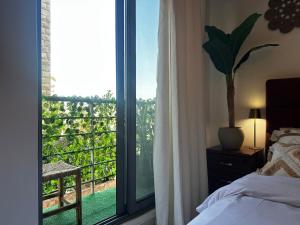 a bedroom with a bed and a large window at Boho studio in Amman