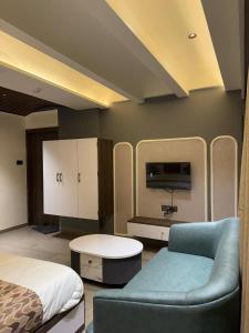 a bedroom with a bed and a couch and a tv at Hotel Vallabh Sky in Goya Gate +42 photos