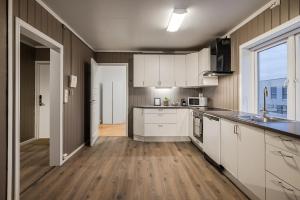 a kitchen with white cabinets and a large window at Fauske Central Apartment - Cozy & Walkable in Fauske