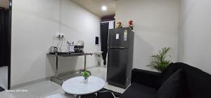 a living room with a refrigerator and a table at Lavish Abode black & white in Guwahati