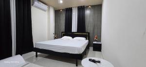a bedroom with a bed with white sheets and white pillows at Lavish Abode black & white in Guwahati