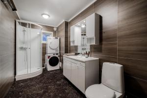 a bathroom with a toilet and a sink and a shower at Fauske Central Apartment - Cozy & Walkable in Fauske