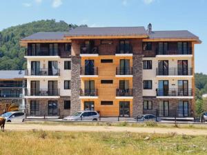 a large building with cars parked in front of it at Bakuriani apartment in Bakuriani