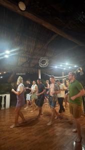 a group of people dancing in a room at Backpackers Hostel in El Paredón Buena Vista