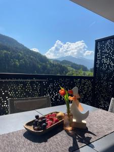 a plate of fruit on a table with a view of mountains at Paradeis Apartments in Mühlbach