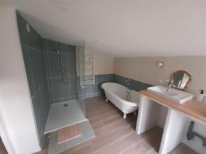 a bathroom with a tub and a sink and a bath tub at Studio nature indépendant in Le Gâvre