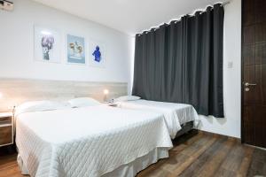 zwei weiße Betten in einem Zimmer mit Fenster in der Unterkunft Studio rent in Piura