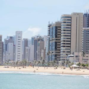 a beach in front of a city with tall buildings at Pousada Maresia in Fortaleza