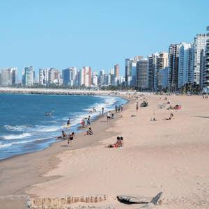 a group of people on a beach with buildings at Pousada Maresia in Fortaleza