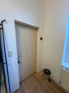 an empty room with a door and a trash can at Beenie 20 in Linz +1 photo