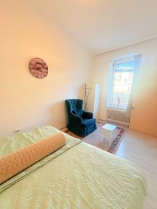 a bedroom with a bed and a chair and a clock at Beenie 20 in Linz
