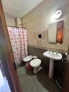 a bathroom with a sink and a toilet and a mirror at La Nueva Vecindad in San Bernardo
