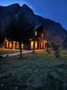 a house in a field with a mountain in the background at Bujtina Alpine Vanat in Bele +42 photos