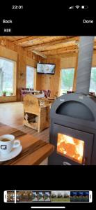 a room with a fireplace and a table with a coffee cup at Bujtina Alpine Vanat in Bele