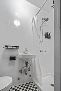 ein weißes Badezimmer mit Waschbecken und Dusche in der Unterkunft CityNest New York in New York