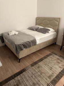 a bedroom with a large bed with white sheets and a rug at Happy moments Studio Kraljevo in Kraljevo