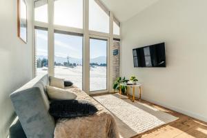 ein Wohnzimmer mit Sofa und großem Fenster in der Unterkunft SkyView Wierch Private Jacuzzi Mountain View in Ząb