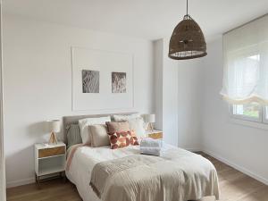 a white bedroom with a bed and a pendant light at Ribeira Sacra Ledicia in Chantada
