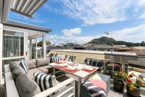 a patio with a table and chairs on a balcony at Longbeach Ocean Paradise in Mount Maunganui +12 photos
