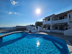 a large swimming pool in front of a house at Pavlis Studios Ormos in Marathokampos +12 photos