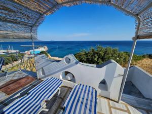 a balcony with two blue and white chairs and the ocean at Pavlis Studios Ormos in Marathokampos