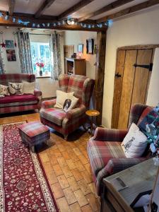 a living room with couches chairs and a table at Cosy Flint Cottage in Thurston