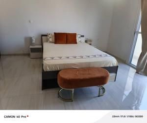 a bedroom with a bed and a stool in it at Serenity in Dakan +4 photos