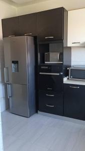 a kitchen with a refrigerator and a microwave at Serenity in Dakan