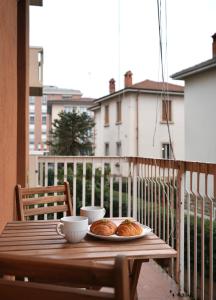 a table with two cups and croissants on a balcony at UNIque Apt Bergamo 2 in Bergamo