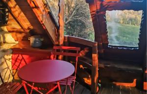 a table and chairs in a cabin with a window at La Tanière in Rosporden