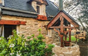 a stone house with a bird feeder in front of it at La Tanière in Rosporden +14 photos
