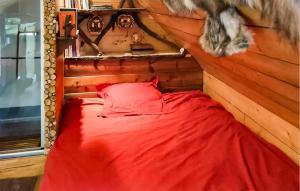 a bedroom with a red bed in a log cabin at La Tanière in Rosporden