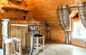 a log cabin kitchen with a table and two stools at La Tanière in Rosporden