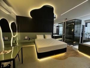 a bedroom with a bed and a table and a glass at Motel Sedución (Adults only) in Cascavel +16 photos