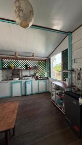 a kitchen with blue and white cabinets and a table at Soul Rebel Hostel in Puerto Viejo