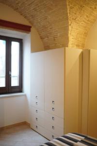 ein Schlafzimmer mit weißen Schränken und einem Fenster in der Unterkunft Dimora Giulia Superba in Terlizzi