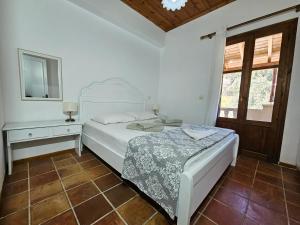 a white bedroom with a bed and a mirror at Lemon Nest in Marathokampos